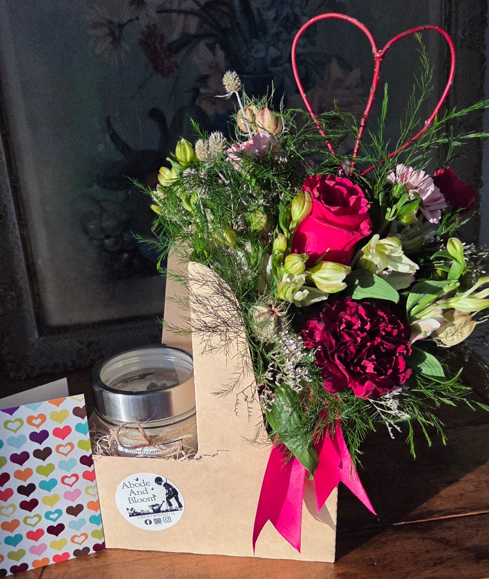 loves blooms candle, exclusive to Abode and Bloom in a carrier with a card and flower bouquet