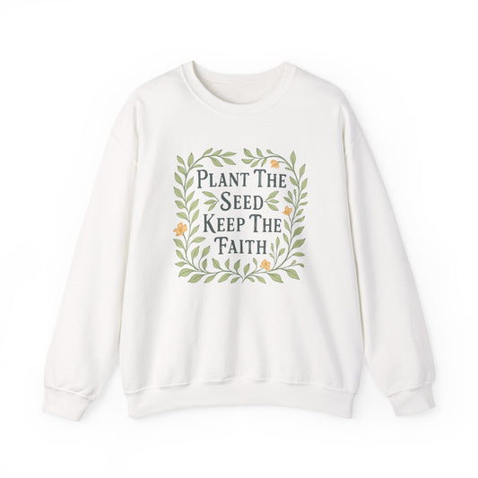 White sweatshirt with 'Plant The Seed Keep The Faith' text and floral design on a white background