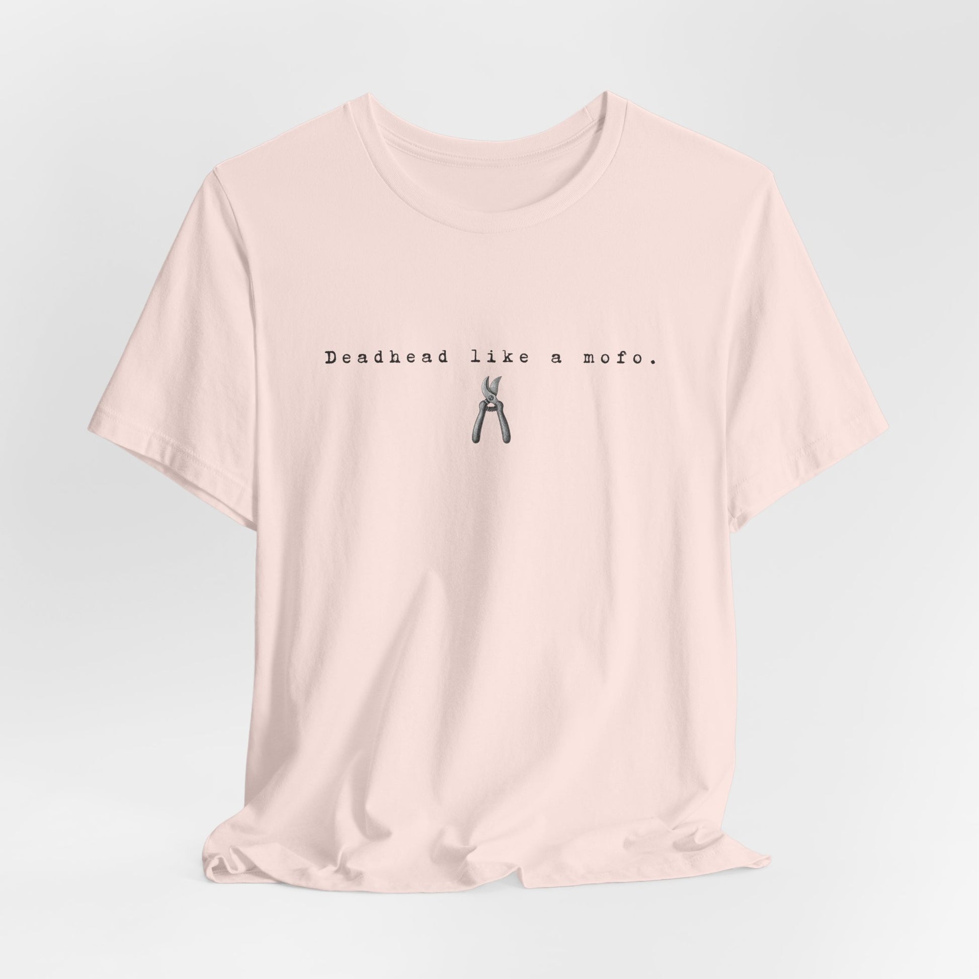 Pink t-shirt with text and graphic on a light gray background