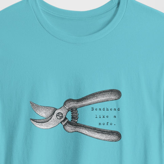 Light blue t-shirt with a graphic of shears and text on a light gray background