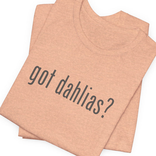 Folded peach-colored tank top with 'got dahlias?' text on a white background