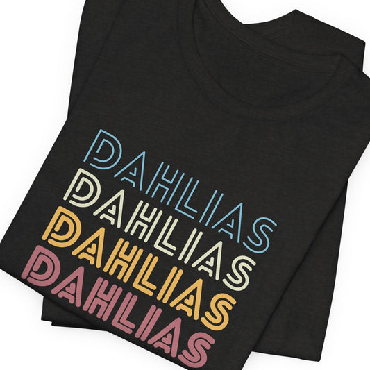 Stack of black t-shirts with 'DAHLIAS' text in different colors on a white background