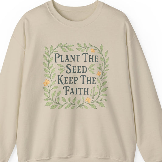 Beige sweatshirt with 'Plant The Seed Keep The Faith' text and design on a white background